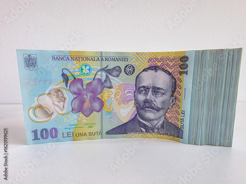 Stack of Romanian Lei bank notes, 100 RON denomination on their side against a white background 