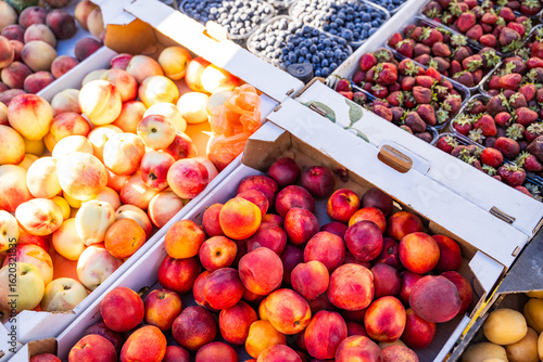 Fotografie Assorted fresh fruits in cardboard boxes at local farmer market, top view of sea
