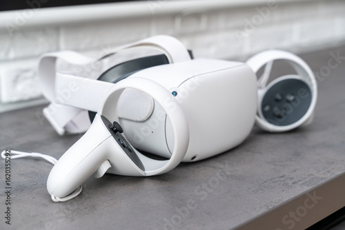 White 3D virtual reality glasses. VR glasses and helmet. Controlled by controllers. Using VR Technology. Futuristic and modern.