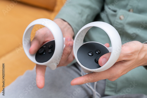 A man holds controllers from 3D virtual reality glasses for playing in the virtual world. Controlled by controllers.