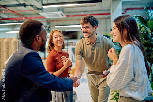 Canvas Print Business partners shaking hands after signing a contract in a modern office, cel