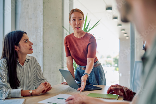 Принти на полотні Asian businesswoman leading a meeting with her colleagues, presenting a project