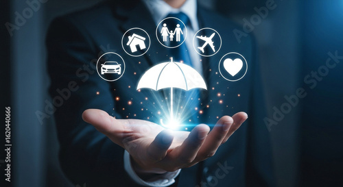 Businessperson holding glowing umbrella with insurance icons above