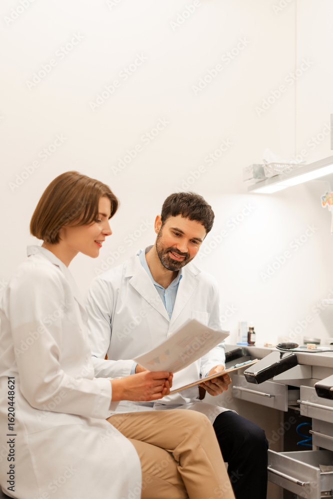 Fototapeta premium Two medical people reading medical records in modern clinic