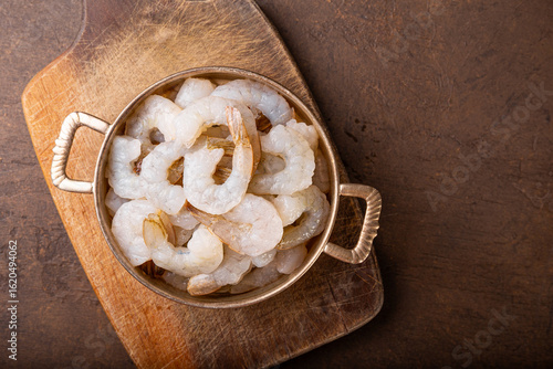  Raw shrimps in a pan on the dark background top view copy space for text