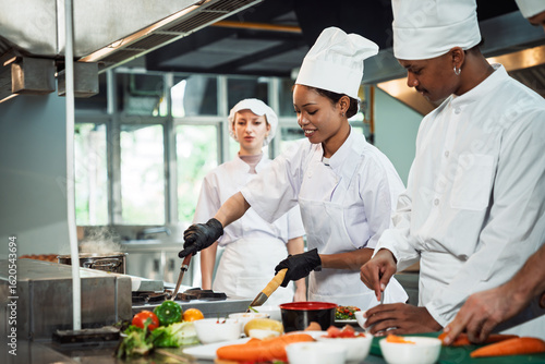 Cooking Class in Commercial Kitchen , Diverse Culinary Student Receives Hands-On Training from Head Chef, Learning with Passion and Focus
