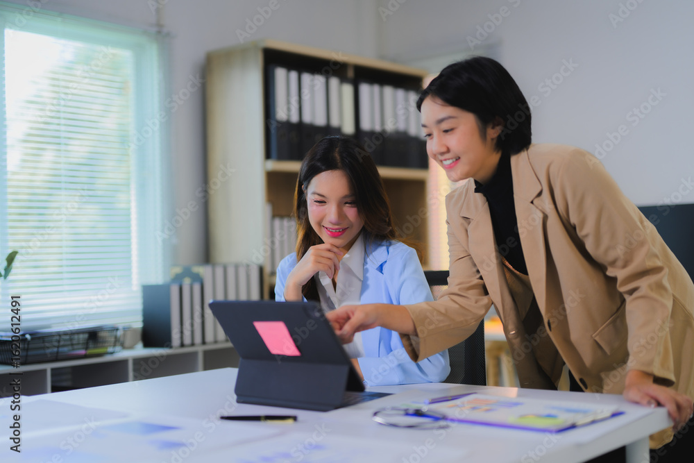 Obraz premium Asian businesswomen discussing and working together using tablet in office
