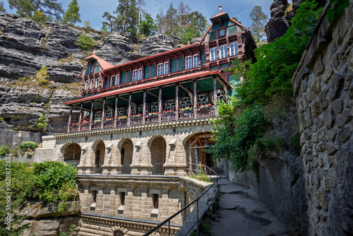 View of the restaurant and hotel high on the mountain near the largest sandstone bridge in Europe, the Pravcicka Brana in the Czech Republic