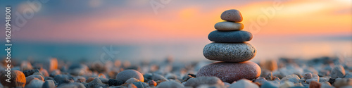 Stacked stones on a pebble beach at sunset creating a sense of balance and peace in nature