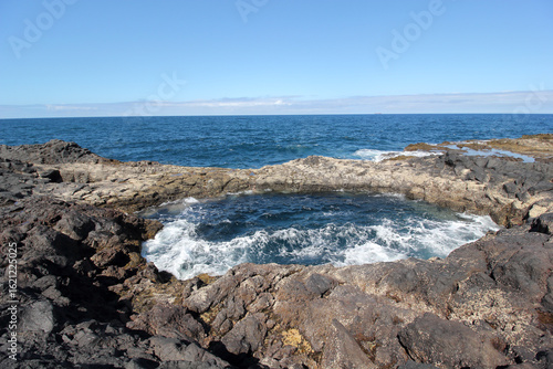 Canvas Print Natural blowhole El Bufadero, Gran Canaria: volcanic rock formation, ocean waves crashing, blue sea, clear sunny sky