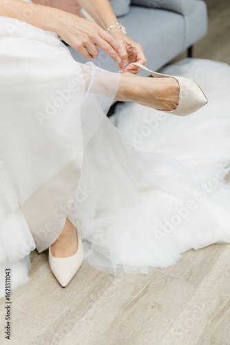 Close up of bride putting on her wedding shoes