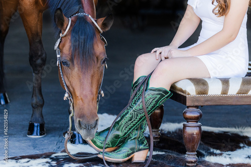 Horse trying to eat her rider's cowgirl boots
