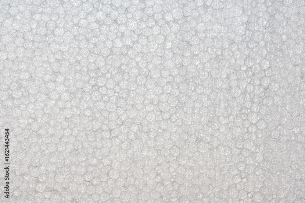Fototapeta premium Close-up texture of white expanded polystyrene foam with round air cells. Lightweight insulation material background used in packaging, construction, and thermal protection. EPS surface macro detail.