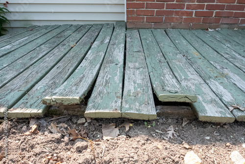 Warped green wooden boards on a porch or deck on a house