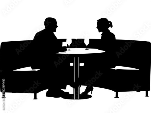 A side silhouette view of a man and woman eating at a booth in a restaurant.
The table is rounded at the edges, with a light-gray top and wine glasses on it. The woman is closer to the viewer, her bun