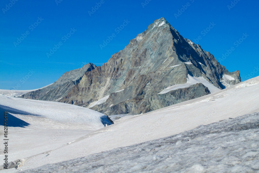 Obraz premium Alps mountains snow ridges view of Monte Rosa massive. Lyskamm, Pollux and Castor summits above the clouds stunning landscape mountains view. Alps high attitude extreme terrain climbing and glacier