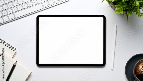 A modern workspace featuring a tablet, keyboard, and coffee, top view.