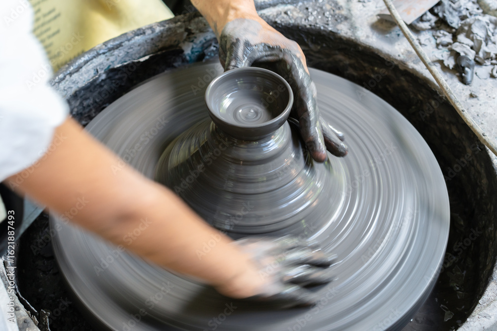 Fototapeta premium Young Artisan Shaping Clay on Pottery Wheel