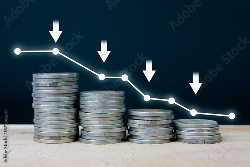 Stacks of coins and a downward trending chart. Economic recession crisis, inflation, stagflation, business concepts and financial losses.