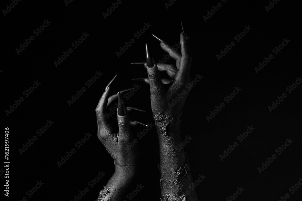 Obraz premium Black hands of witch on dark background. Halloween celebration