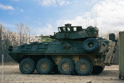 Armored on Patrol, A armored vehicles carrying armed soldiers advances along a dirt path during a field training exercise.