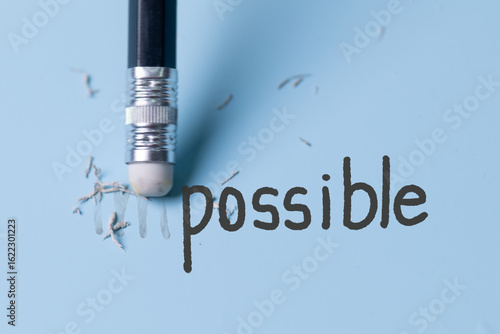 Changing the word impossible to possible with a pencil eraser.Examination for fix and correct or change some incorrect and problem in business concept.