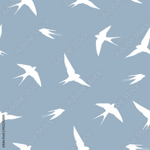 Vector seamless pattern with silhouettes of swallows soaring in the sky