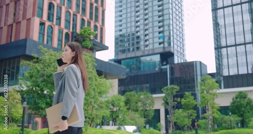 Confident Businesswoman Talking on Phone Holding Documents
