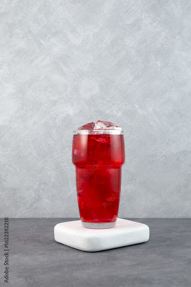 Obraz premium Red iced drink. Glass of refreshing summer drink with ice cubes. Karkade ice tea. Hibiscus cocktail