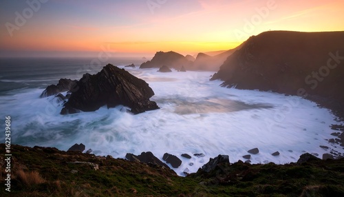 Dramatic coastal landscape at sunset with rugged cliffs and powerful waves