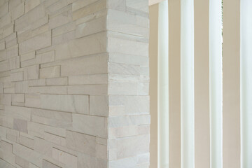 Modern corner of stacked stone wall with modern vertical white panel background