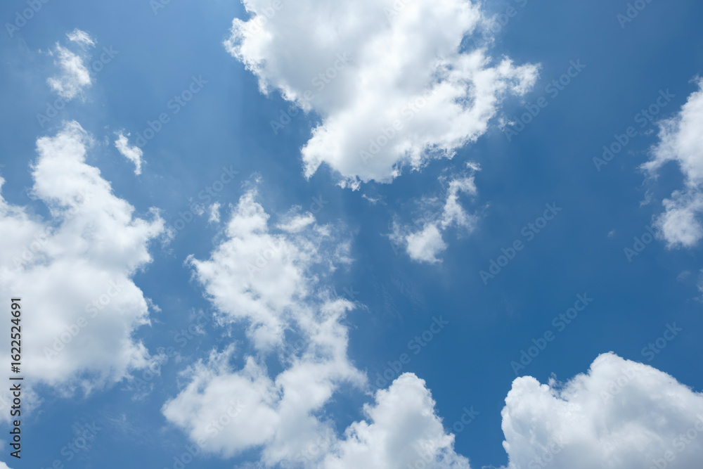 夏の暑い日差しに照らされた青空とふわふわ漂う雲 季節の風景・夏休み・バカンス・猛暑・積雲の背景 夏の暑い日差しに照らされた青空とふわふわ漂う雲 季節の風景・夏休み・バカンス・猛暑・積雲の背景