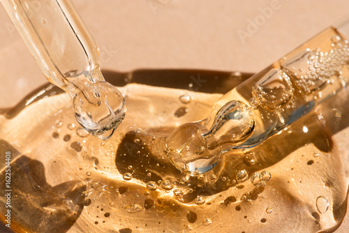 Glass skin care tools with gel, oil, essence beige background, macro.