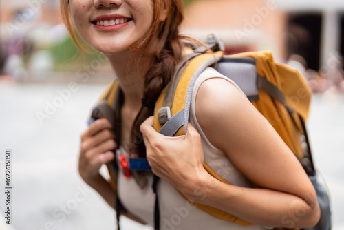 Travel. Close-up of young woman smiling with backpack, ready for adventure.