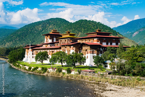 Tableau sur toile A stunning view of Punakha Dzong, one of Bhutan’s most iconic and historic fortress-monasteries, nestled between lush green mountains and the confluence of two rivers