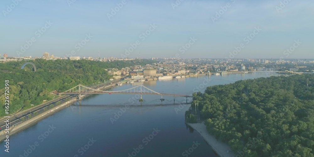Fototapeta premium Wide river in city with bridge. Cityscape architecture