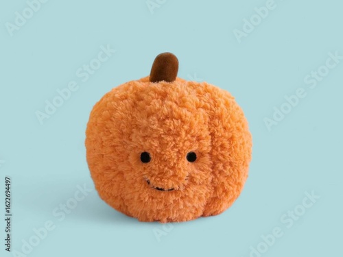 Cute Plush Pumpkin Toy with Smiling Face on Blue Background