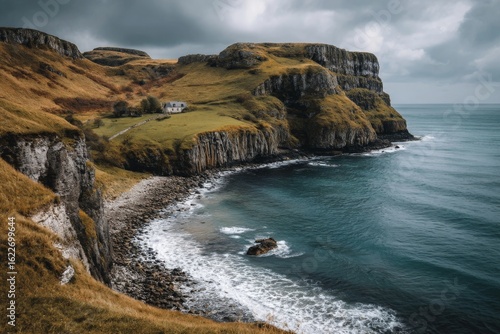 Coastal cliffs and serene waters at dusk in a remote landscape overlooking a quaint house
