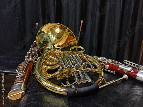French horn and two bassoons on a black background
