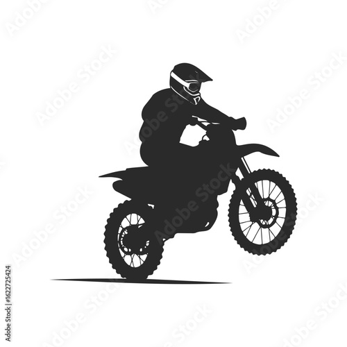 Silhouette of a motorcyclist performing a wheelie on a dirt bike