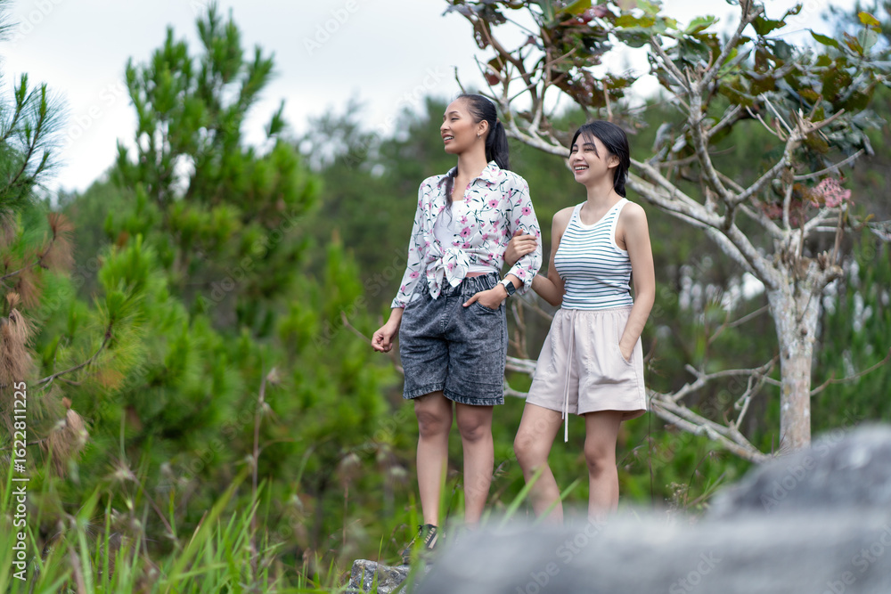 Two Asian Indonesian Women Exploring Rocky Forest Landscape in Yogyakarta Two Asian Indonesian Women Exploring Rocky Forest Landscape in Yogyakarta