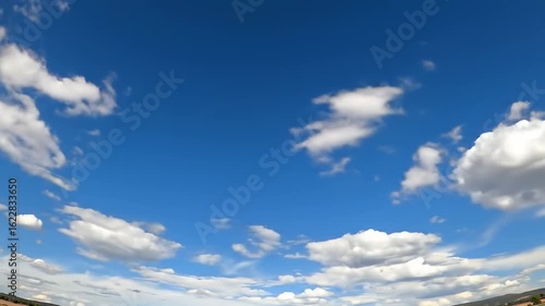 A vibrant blue sky filled with fluffy white clouds