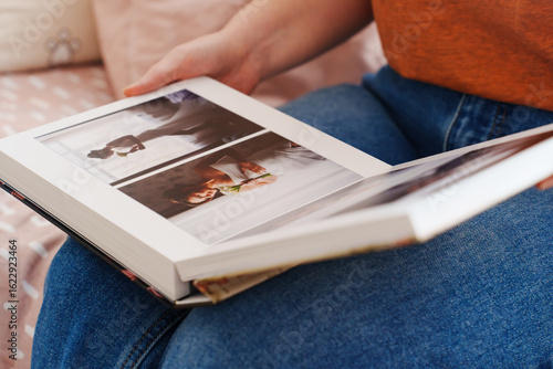 Tableau sur toile Female hands flipping through a photo book with wedding photos