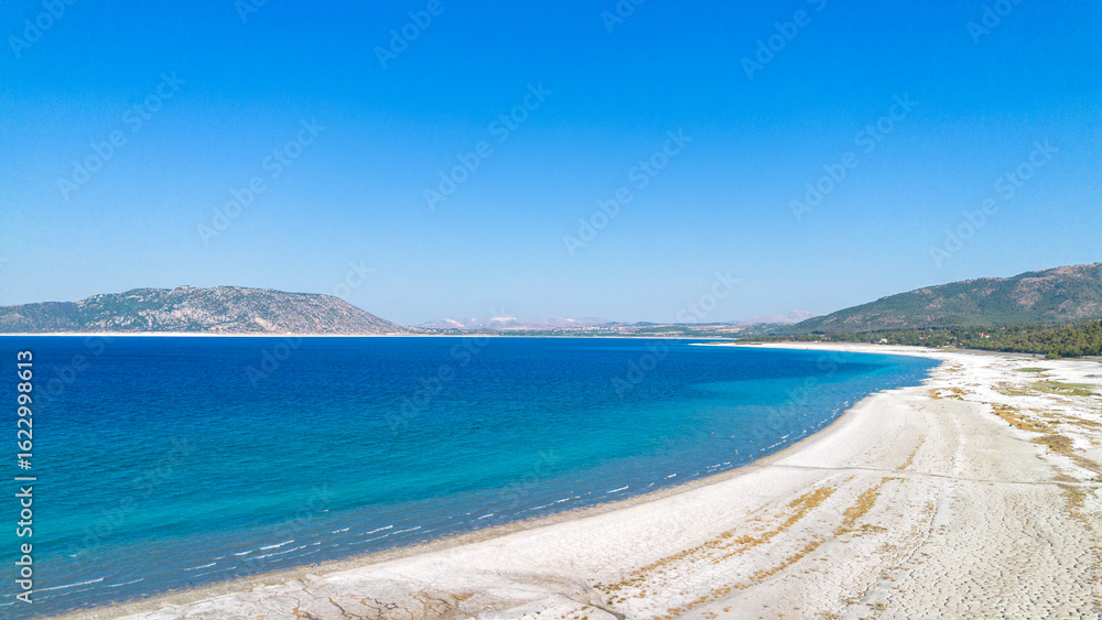 Fototapeta premium The tranquil beauty of Salda Lake - Turkey with its crystal clear turquoise waters and stunning surrounding landscapes is a mesmerizing sight to behold.