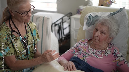 Wallpaper Mural A friendly nurse attentively checks the vitals of an elderly woman while they share a conversation in a senior living facility, ensuring comfort and care. Torontodigital.ca
