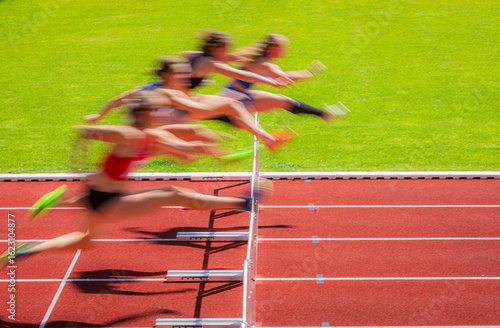 hurdle race track with woman crossing the hurdles