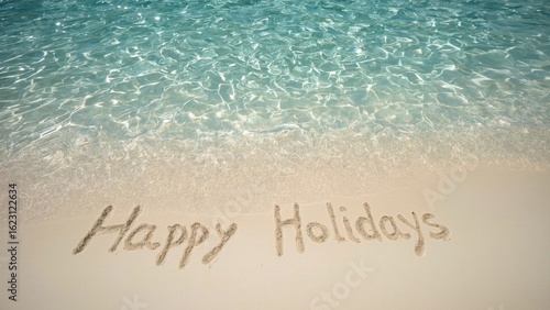 Happy Holidays Written in the Sand by the Ocean Shoreline with Crystal Clear Water