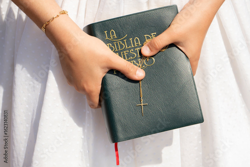 A girl's hands holding the Bible at her First Communion