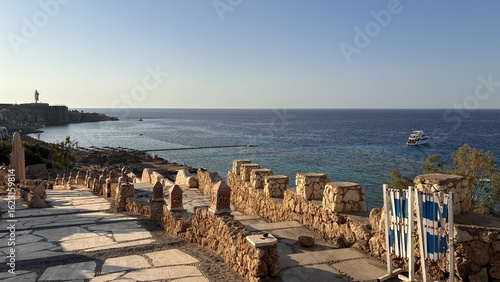 Coastal Promenade with Stone Walls and Clear Blue Sea View