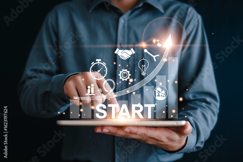 Businessman using a tablet with virtual start up icons and growth graph representing project initiation and business development strategies for success